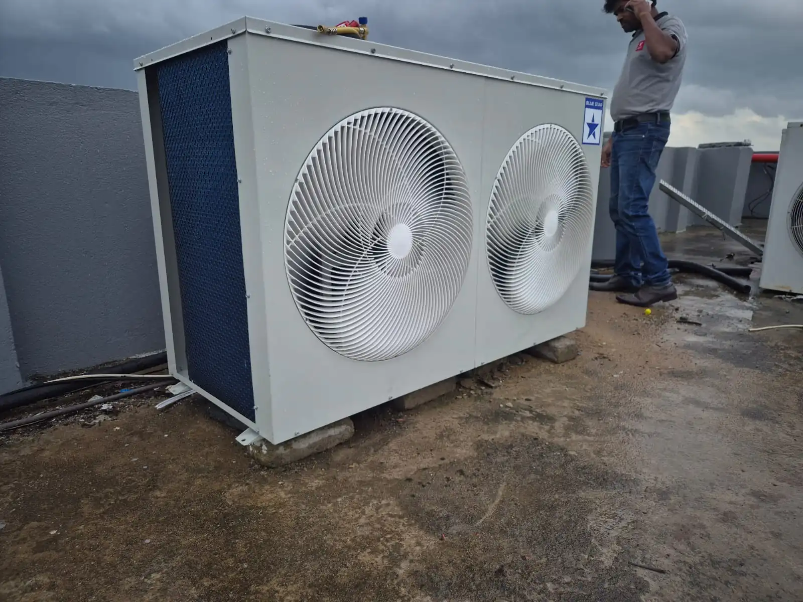 Technician installing a split AC indoor unit on a wall