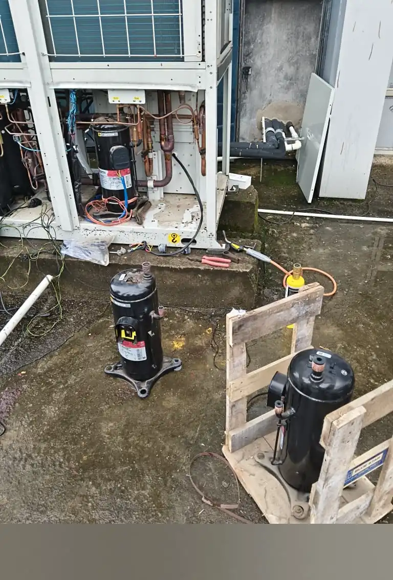 Technician checking electrical connections on an AC unit during maintenance